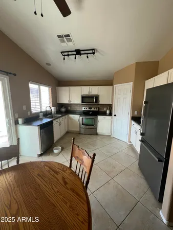 a kitchen with stainless steel appliances granite countertop a refrigerator sink and stove