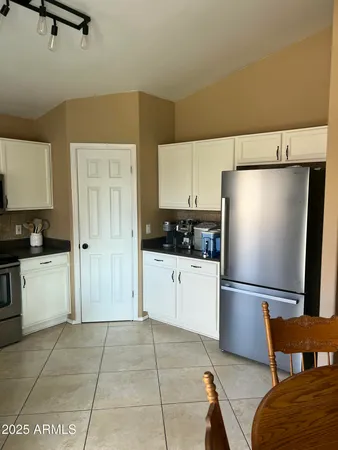 a kitchen with a refrigerator and white cabinets