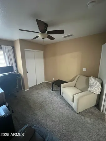 a living room with furniture and a ceiling fan