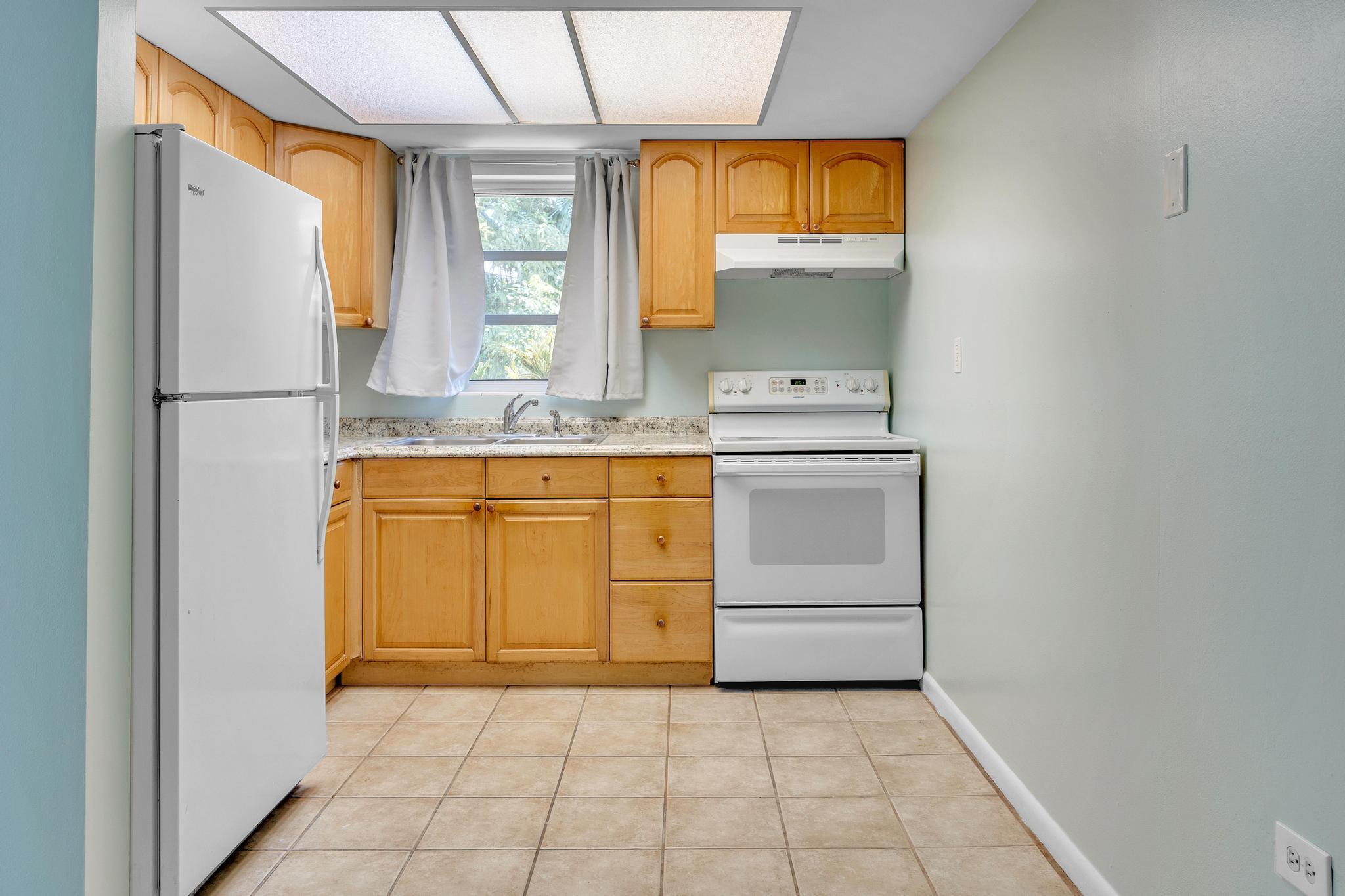 1129 Pebble Beach Lane, Unit 6 Marathon, FL 33050 - Photo 6 of 32 a kitchen with a stove a sink and a refrigerator