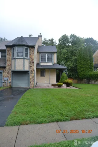 a front view of a house with a garden and plants