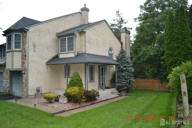 a view of a backyard with wooden fence and trees