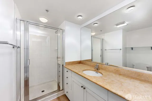 a bathroom with a granite countertop sink mirror and shower