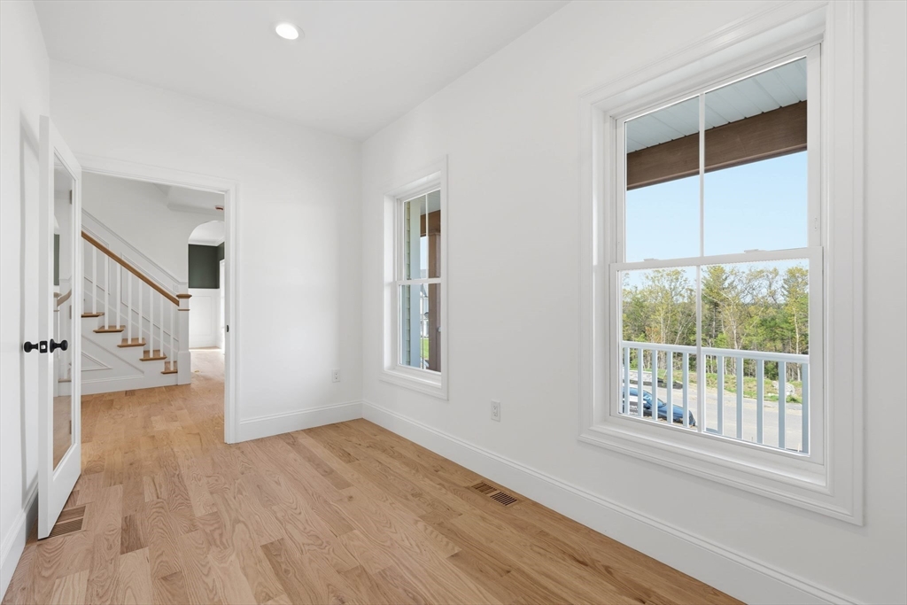 16 Couture Way Middleton, MA 01949 - Photo 5 of 36 a view of an empty room with wooden floor and a window