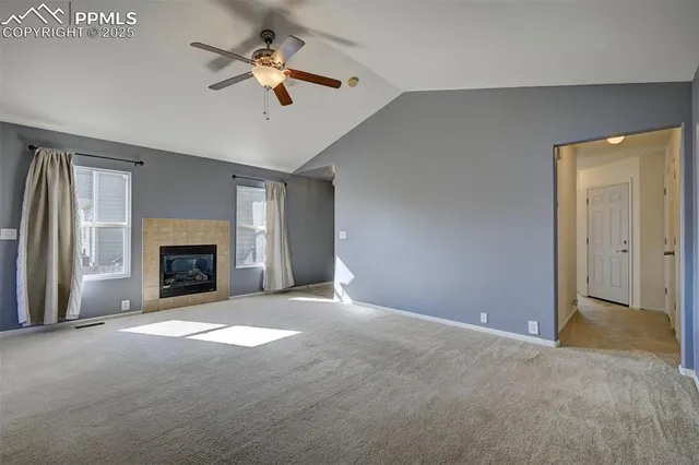 a view of a livingroom with a fireplace and a ceiling fan