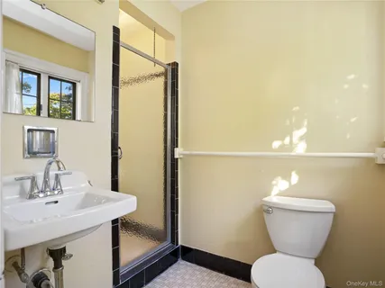 a bathroom with a sink toilet and a mirror