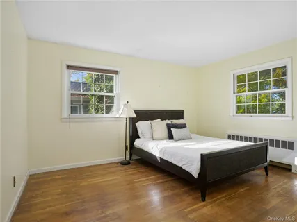 a bedroom with a bed and next to a window