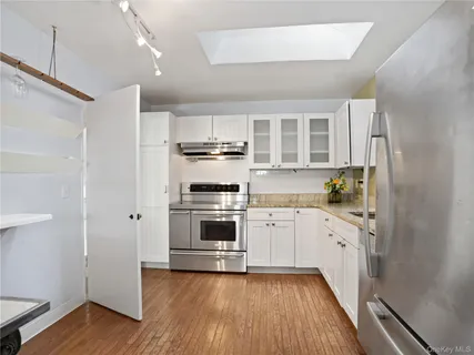 a kitchen with granite countertop a refrigerator and a stove top oven
