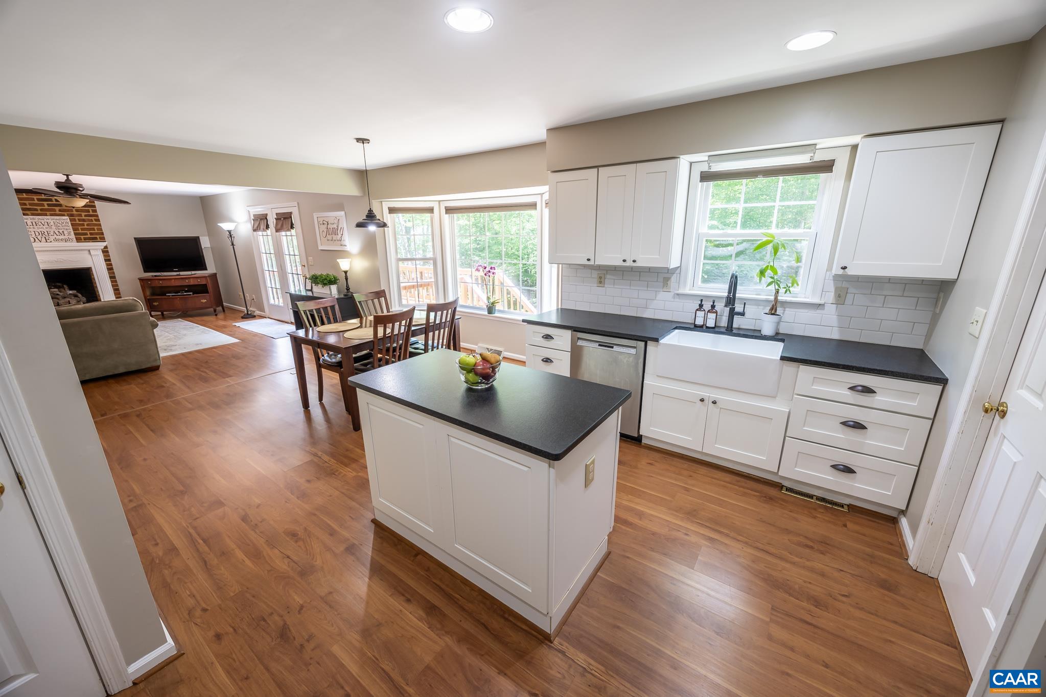 3221 Poplar Ridge Road Charlottesville, VA 22911 - Photo 18 of 72 a kitchen with wooden cabinets a sink a counter top space and living room view