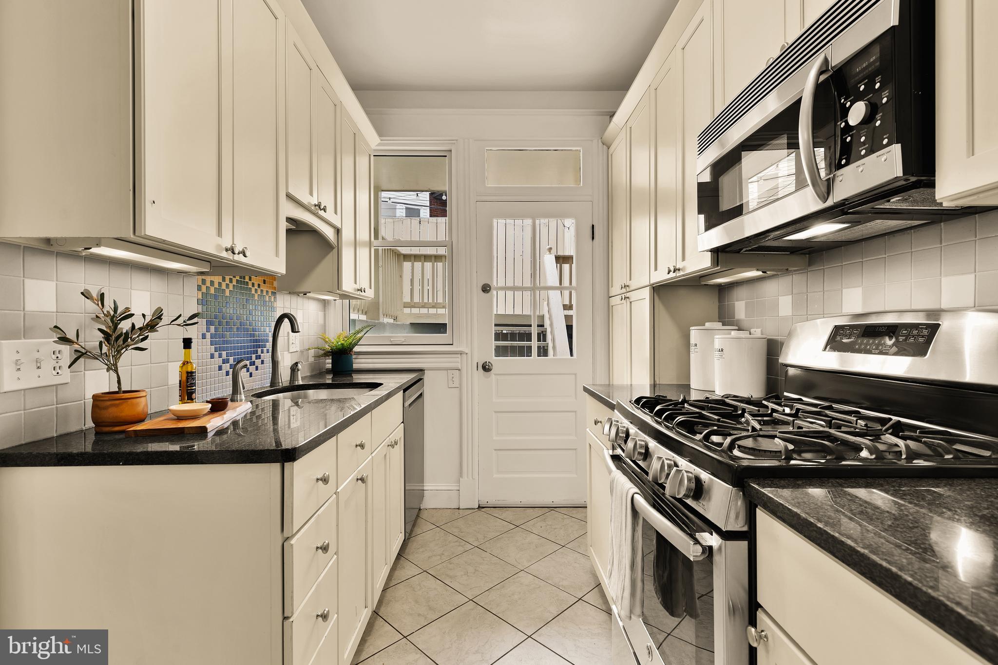 222 Tennessee Avenue Northeast Washington, DC 20002 - Photo 8 of 29 a kitchen with stainless steel appliances granite countertop a stove a sink and a white cabinets