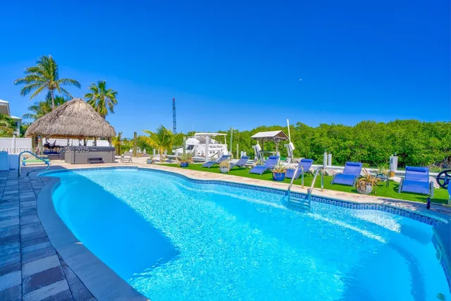 a bathroom with a granite countertop sink a toilet a mirror and shower curtain
