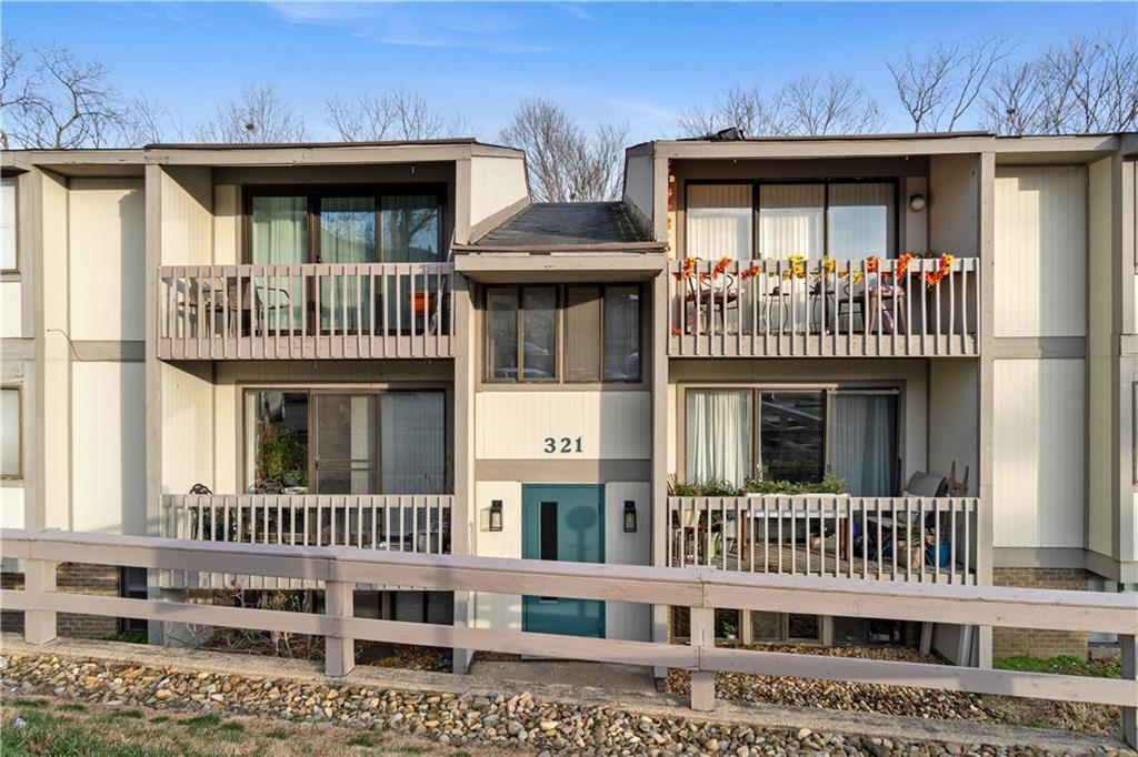 a view of a brick house with large windows and a yard