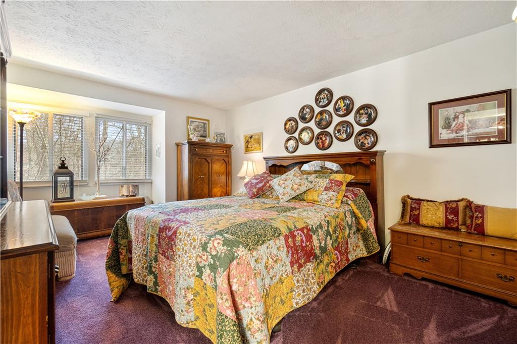 321 Ridge Point Circle, Unit 33B Bridgeville, PA 15017 - Photo 20 of 25 a bedroom with a bed and wooden floor