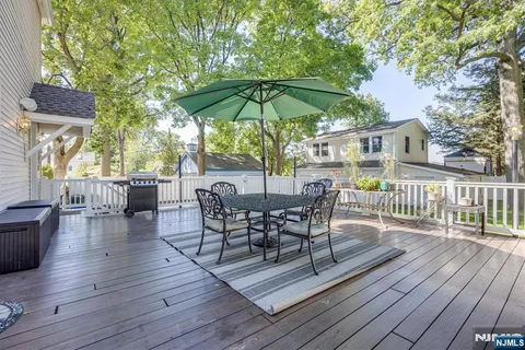 a view of a roof deck with table and chairs under an umbrella with wooden floor
