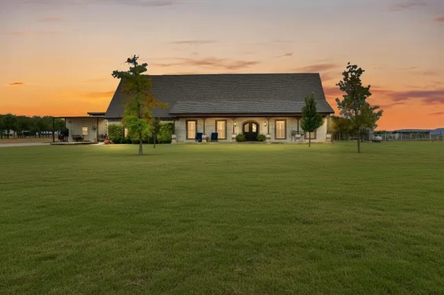 a view of a big house with a big yard and large trees