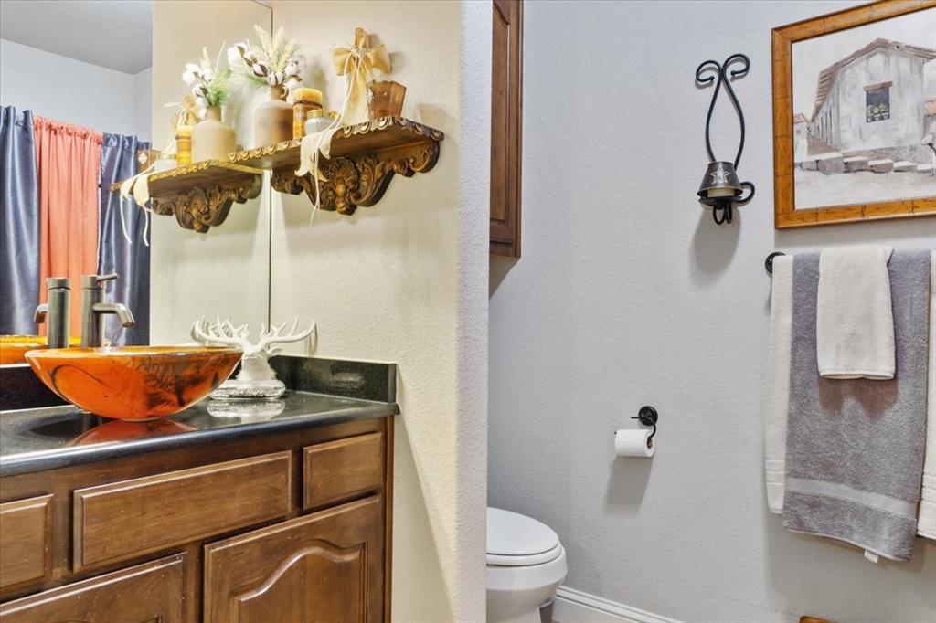 2170 Derrs Chapel Road Italy, TX 76651 - Photo 21 of 38 a bathroom with a granite countertop sink a toilet and shower
