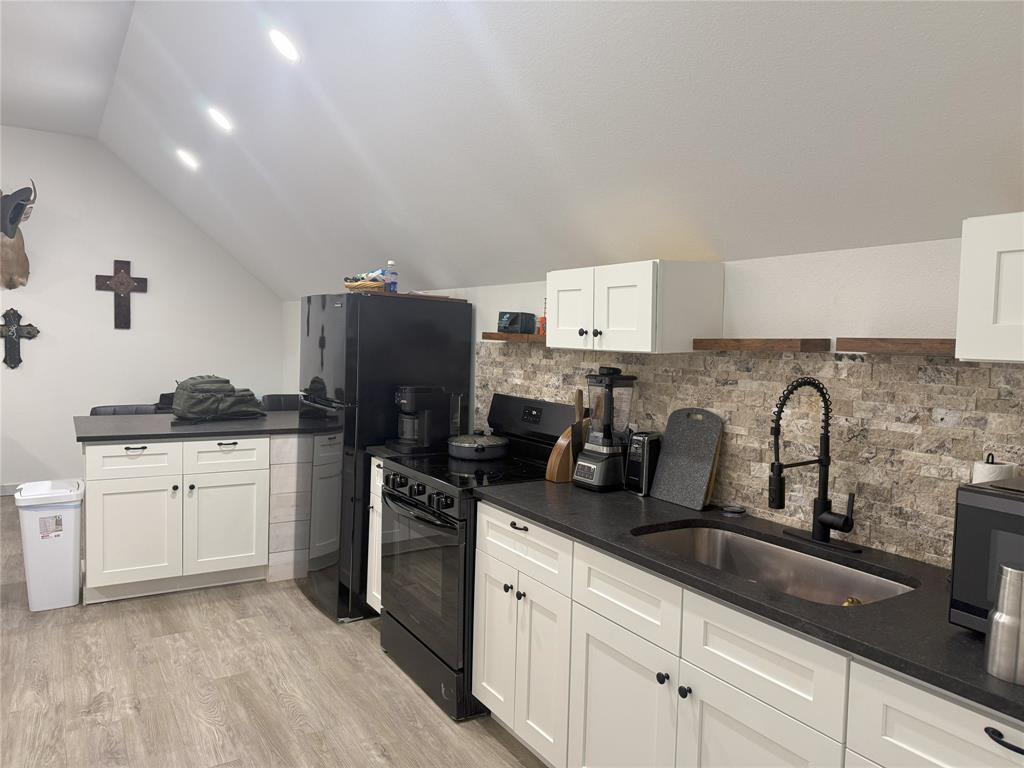 2170 Derrs Chapel Road Italy, TX 76651 - Photo 27 of 38 a kitchen with granite countertop a sink stove and refrigerator