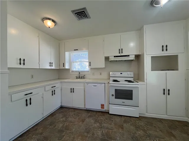 a kitchen with granite countertop white cabinets and white appliances
