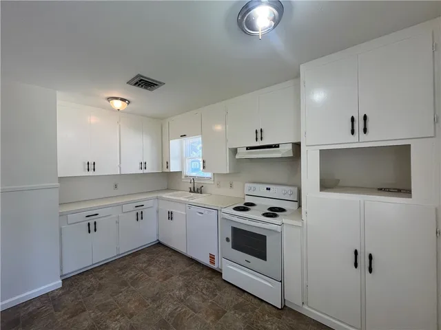 a kitchen with white cabinets stainless steel appliances and sink