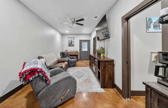 a living room with furniture a flat screen tv and a table