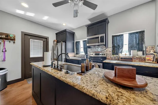 a kitchen with sink refrigerator and cabinets