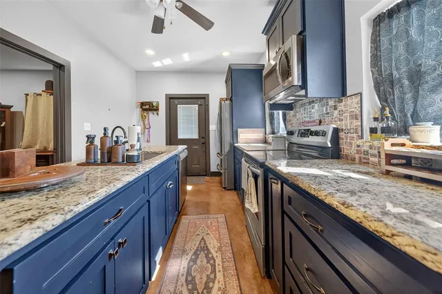 a kitchen with stainless steel appliances granite countertop a sink stove and cabinets