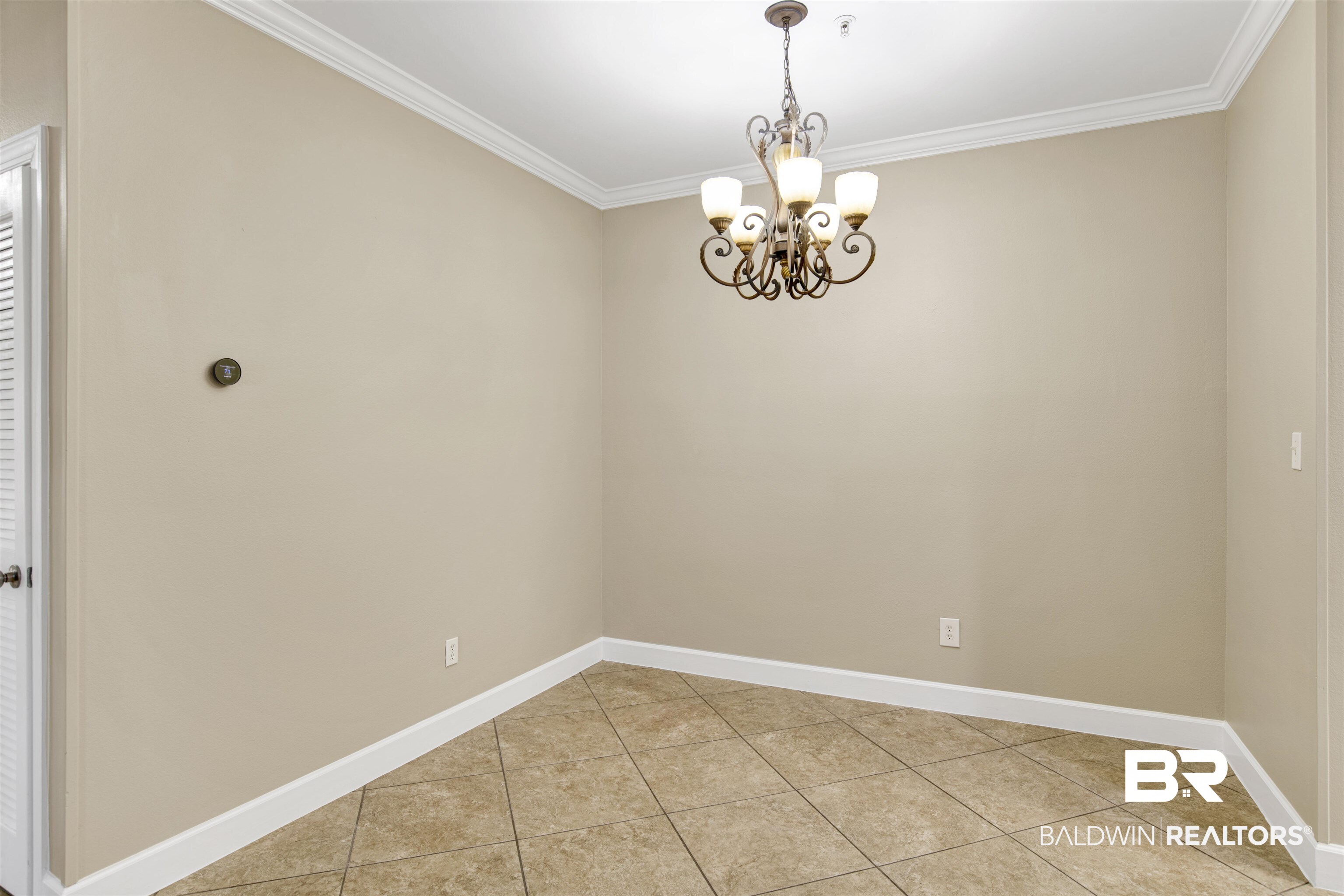 450 Park Avenue, Unit 202 Foley, AL 36535 - Photo 4 of 18 Spare room featuring ornamental molding, light tile patterned floors, and a chandelier