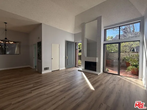 a view of a livingroom with wooden floor a fireplace and window