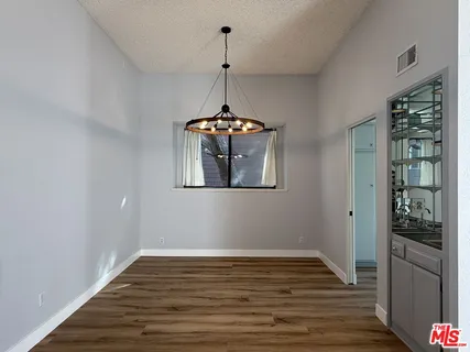 a view of a room with wooden floor chandelier and entryway