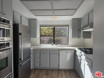 a kitchen with stainless steel appliances a refrigerator sink and stove