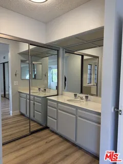 a spacious bathroom with a granite countertop sink mirror and bathtub