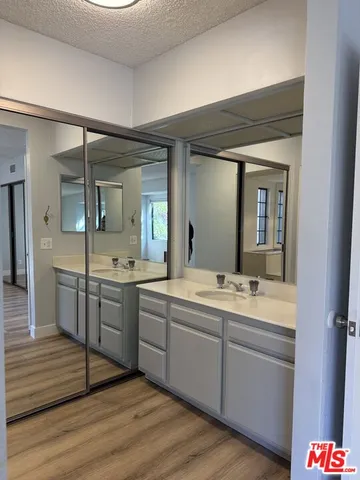 a spacious bathroom with a granite countertop sink mirror and bathtub