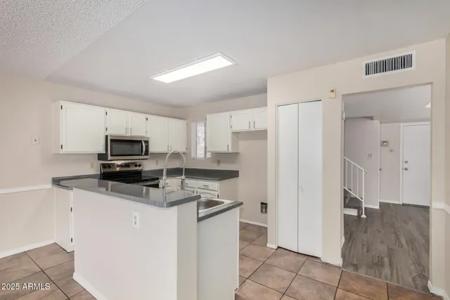 a kitchen with granite countertop a sink and stainless steel appliances