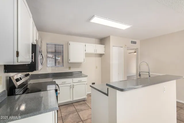 a kitchen with appliances a sink and cabinets