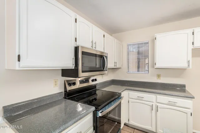 a bathroom with a granite countertop sink and a toilet