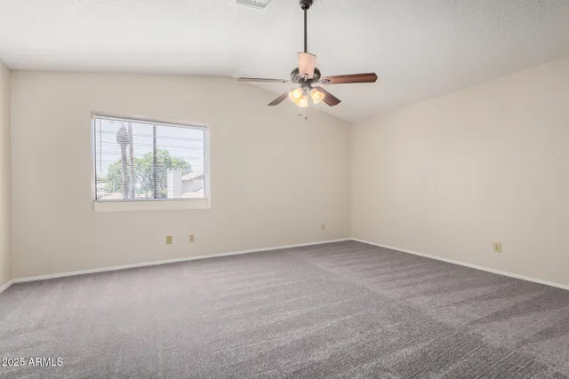 an empty room with a window and a fan