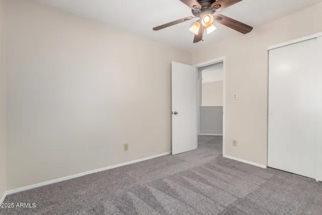 an empty room with a window and a fan