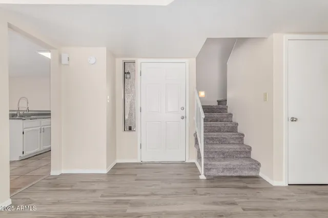 a view of an empty room with wooden floor fireplace and a window