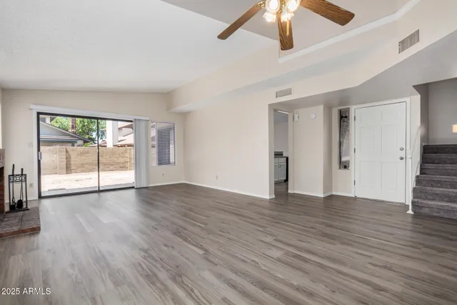 wooden floor fireplace and windows in an empty room