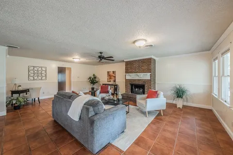 a living room with furniture a fireplace and a window