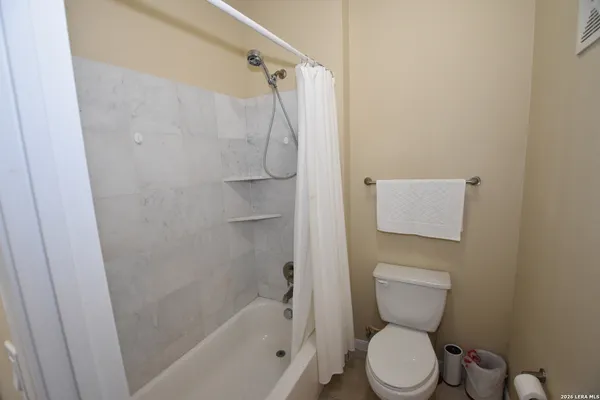 a white toilet sitting next to a bath tub