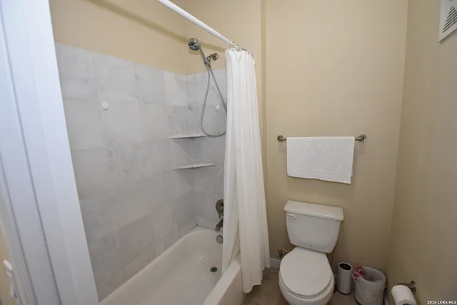 a white toilet sitting next to a bath tub
