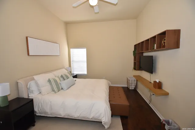 a bedroom with a bed and a flat tv screen on dresser