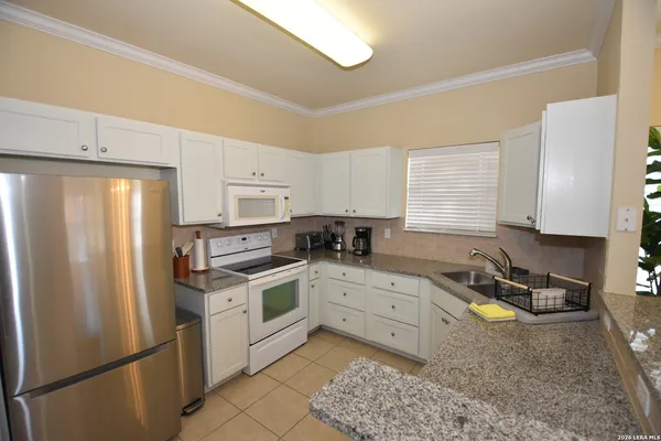a kitchen with a refrigerator stove top oven and sink