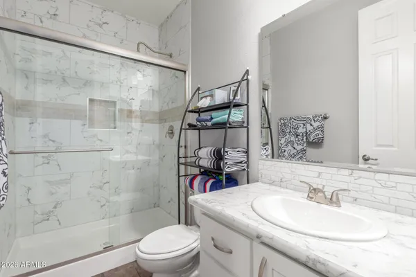 a bathroom with a sink toilet vanity and shower