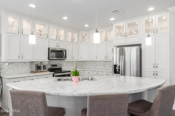 a kitchen with kitchen island granite countertop a sink a center island stainless steel appliances and cabinets
