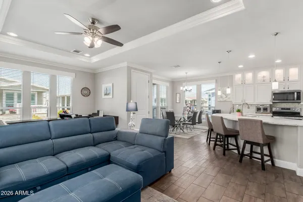 a living room with furniture kitchen view and a chandelier