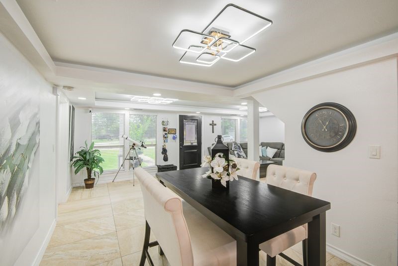 1256 2nd Street Clute, TX 77531 - Photo 11 of 43 a dining room with wooden floor a chandelier a wooden table and chairs