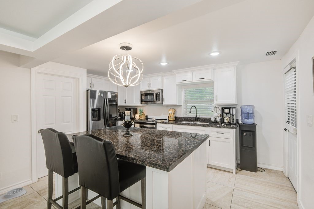 1256 2nd Street Clute, TX 77531 - Photo 12 of 43 a kitchen with stainless steel appliances granite countertop a stove top oven a sink dishwasher a dining table and chairs