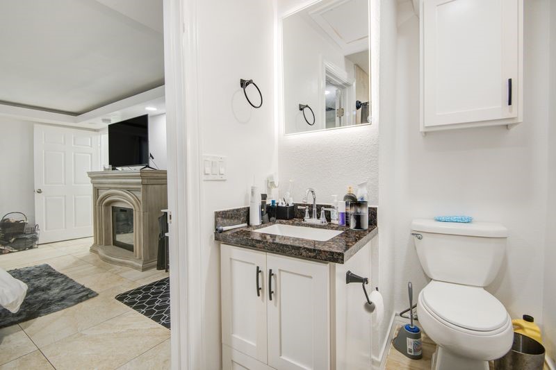 1256 2nd Street Clute, TX 77531 - Photo 22 of 43 a bathroom with a granite countertop toilet sink and mirror